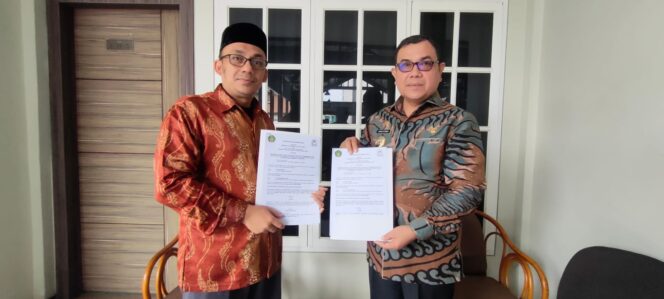 
 Pj Bupati Aceh Barat, Drs. Mahdi Effendi dan Dekan Fakultas Syariah dan Hukum UIN Ar-Raniry Banda Aceh, Dr. Kamaruzzaman Bustamam Ahmad menunjukkan Nota MoA (Memorandum of Understanding Action) yang telah disepakati kedua belah pihak di Hotel Meuligo, Aceh Barat, Kamis, 20 Oktober 2022. Foto/ Im Dalisah Gumpalanews.com